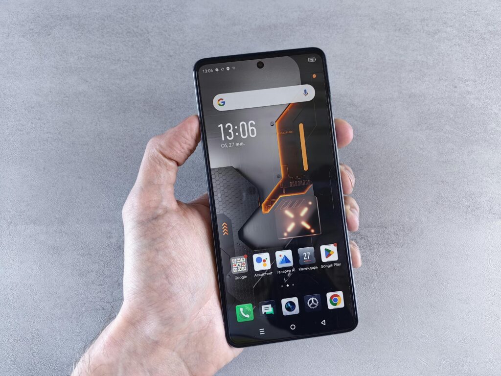 Close-up of a hand holding a smartphone displaying a modern interface with Russian text.