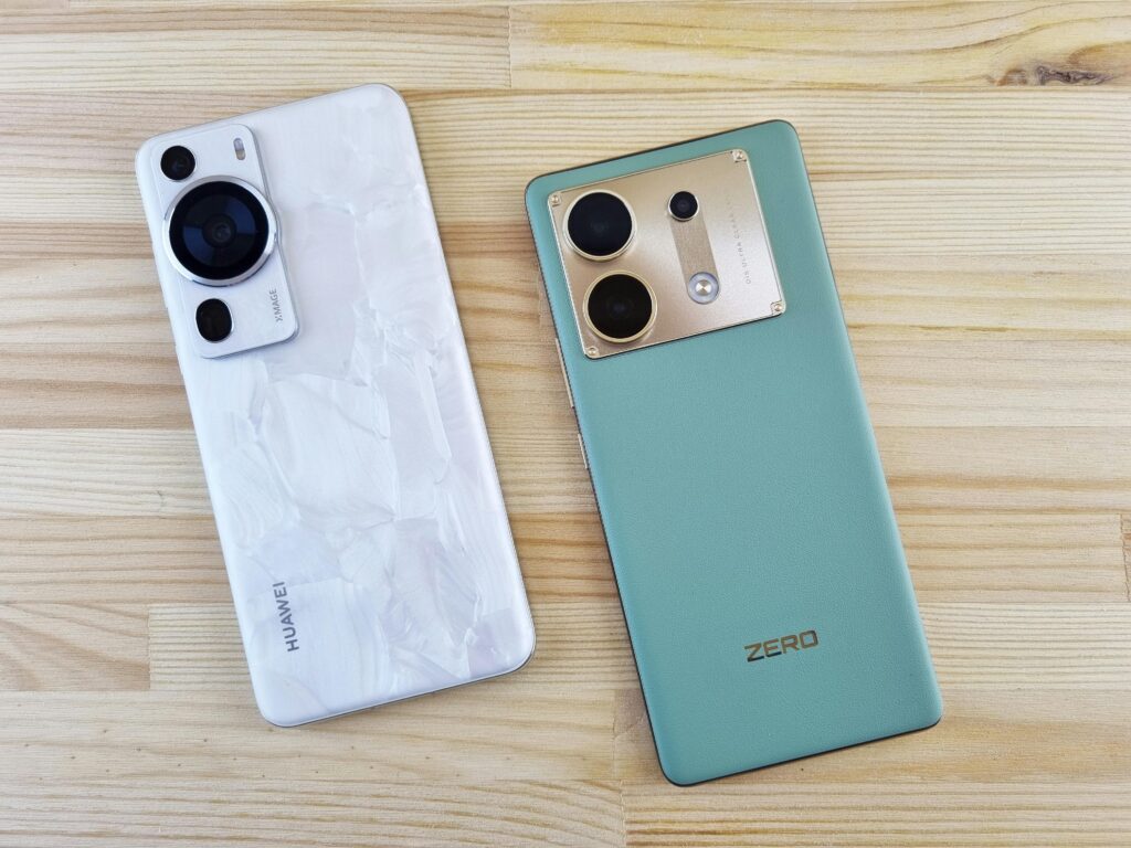 Close-up of two modern smartphones on a wooden table, contrasting designs and colors.